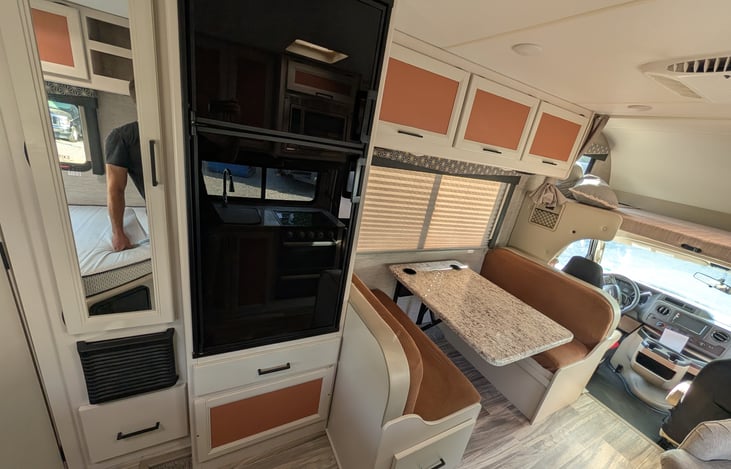Bright, modern interior with a cute pop of color! Features a cozy rear queen bed, fully equipped kitchen, converting dinette, over-cab bunk, and an accent armchair. Clean, open, and ready for adventur