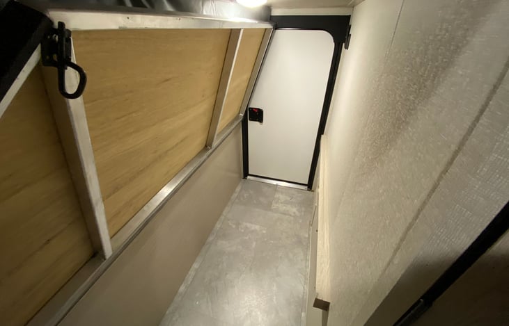 Bottom bunk flipped up with access door in the rear