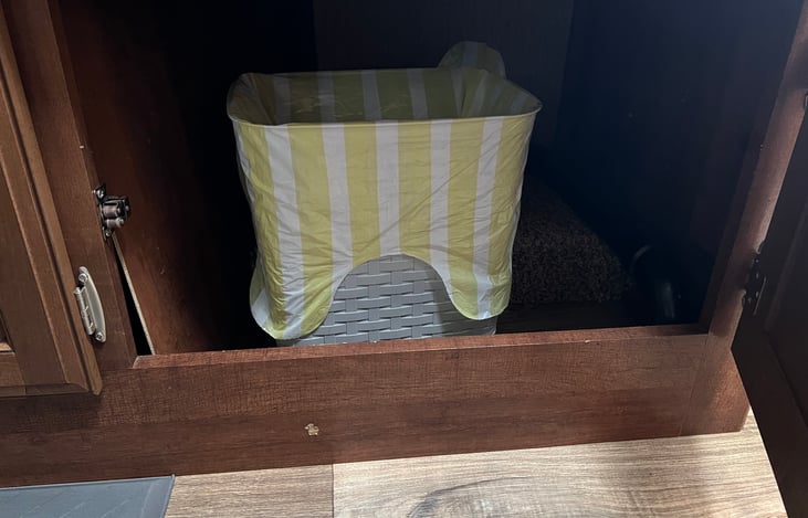 Trash cans in kitchen and bathroom with bags.