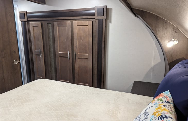 Master bedroom, secondary walkway to bath. Ample closet storage! Also enjoy the secondary heater/AC above the bed with all 50 AMP hookups. There are bedside tables, with plugs and USB chargers.