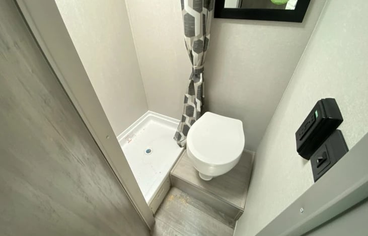 Raised commode for comfort, separate from shower.