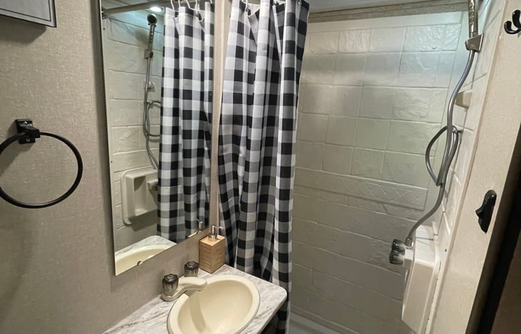 Shower and wash sink with running hot and cold water. Hand soap, toilet paper, and santipods included.