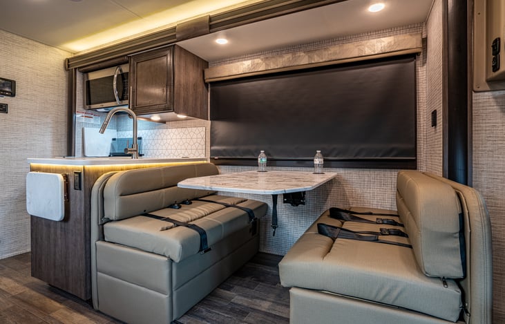 The dinette table easily seats 4 adults.  The tabletop can easily be converted into a sleeping space.