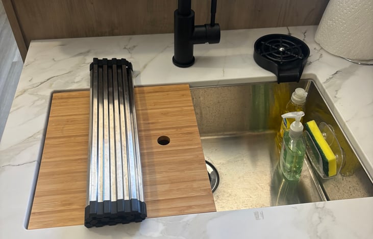 large sink with cup rinser and detachable hose for dishes, sponge and soap provided