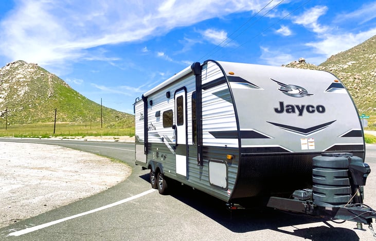 Jayco Jay Flight catching the sun! Start your affordable RV rental journey with this Jam Caravan — a true gem among travel trailers.