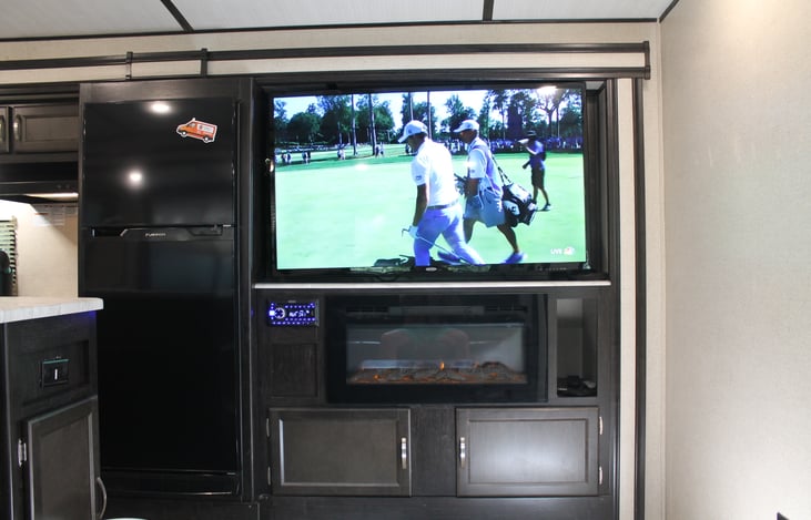 Big screen TV and fireplace in living area.
