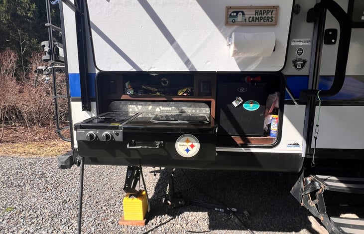 Full outdoor kitchen under the awning which allows for outdoor cooking during inclement weather and an escape from the midday sun.