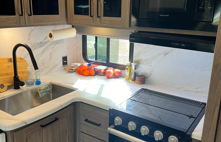 Kitchen area; microwave, cooktop & oven fully functioning with lots of storage! Under the sink garbage can storage