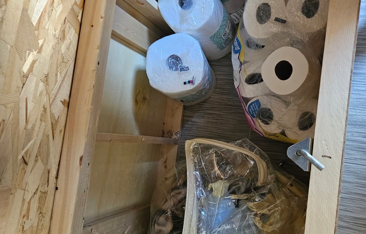 Extra blankets, toilet paper and paper towel under front queen bed storage