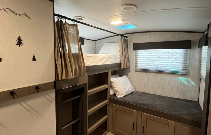 Shelves and large storage compartment in bunkroom.
