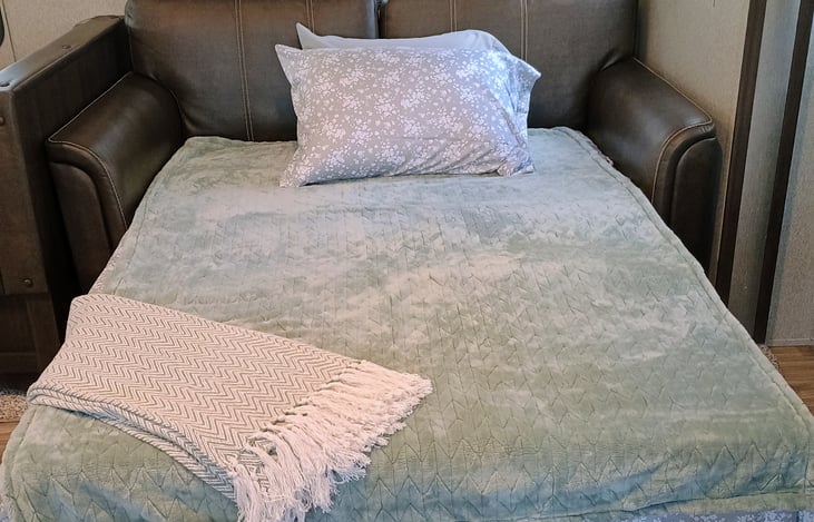 Couch pulls out into a full size bed, with extra linen.