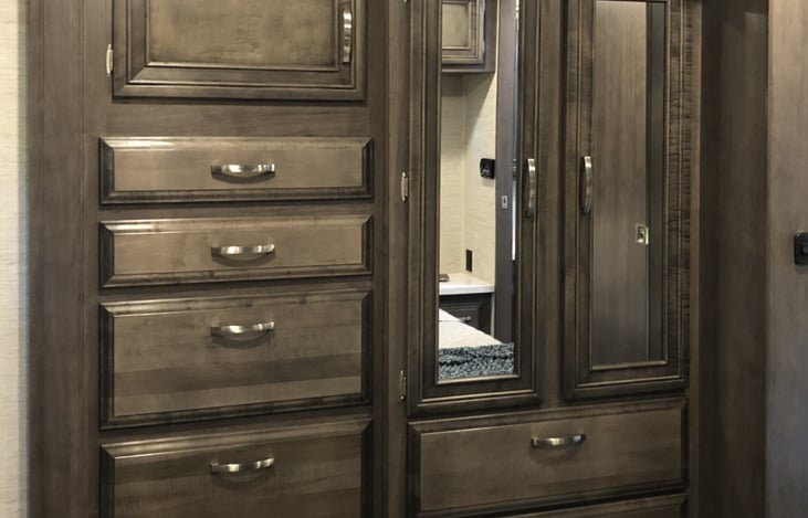 Main bedroom has tons of drawers and a closet for hanging clothes. Also comes with iron and ironing board.