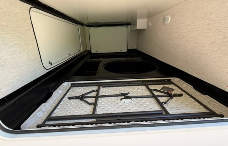 Huge storage area accessible from back or sides of the camper. Also shown is a camping table because more outside table space is always needed!
