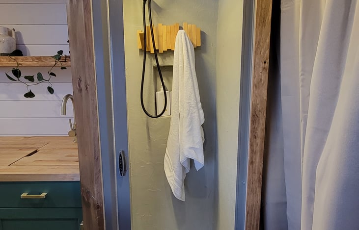 Well-lit shower with towel hooks and soap nook