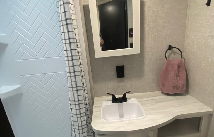 Bathroom stocked with toilet paper and handsoap as well as basic first aid supplies