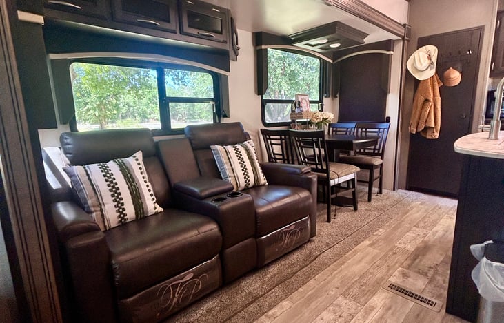 "Relax in Comfort: Plush theater-style recliner seating with a perfect view of the fireplace."