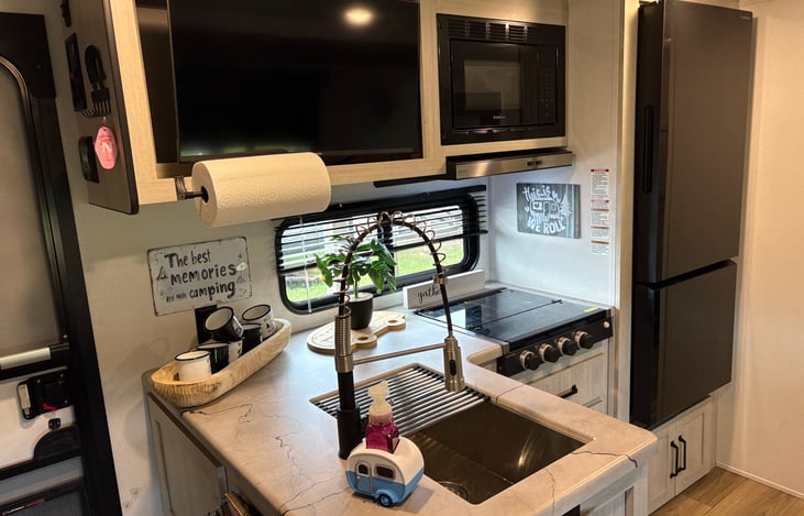 Cute clean little kitchen. Toaster over and coffee pot in cabinet.