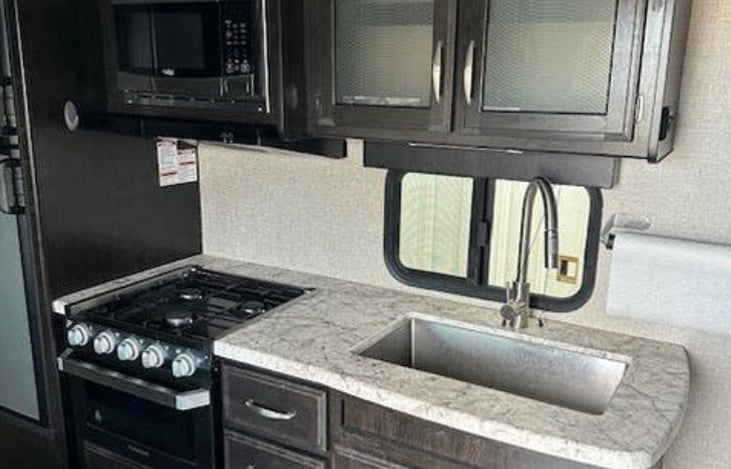 Kitchen Area: Modern kitchen with stovetop, oven, and plenty of storage.