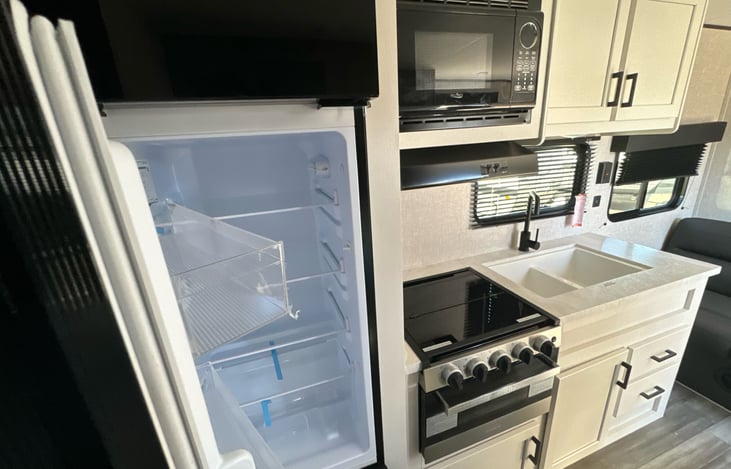 Kitchen including refrigerator, freezer, microwave, stove, sink, and cabinets