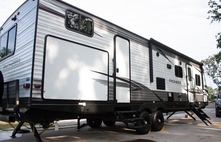Discover the ultimate outdoor cooking experience in this camper, equipped with an outdoor kitchen. Complete with a convenient sink, a refrigerator to keep ingredients fresh, and ample storage.