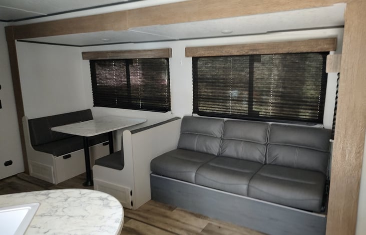 Main living area has a jackknife sofa that converts to a bed and a booth that also makes out into a bed.