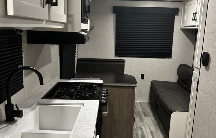 Kitchen, sink, table and storage compartment.