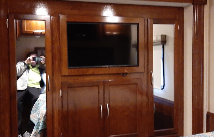 Master bed room, flat screen tv/dvr and shelving with mirrors.