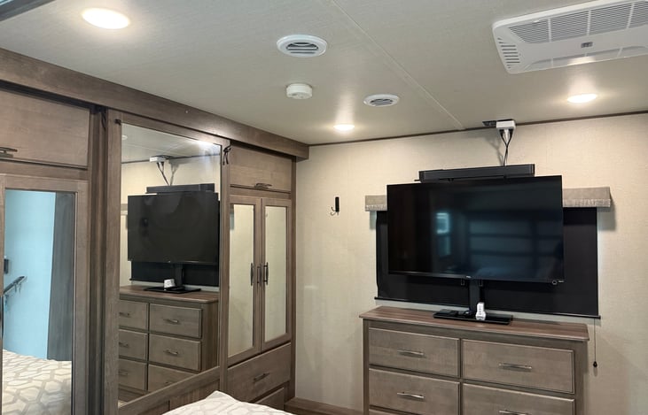 Master bedroom: dresser, Smart tv and soundbar, plus separate AC unit.
