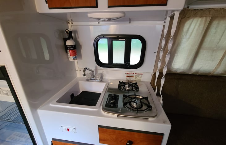 Two burner stove and sink with hot and cold water