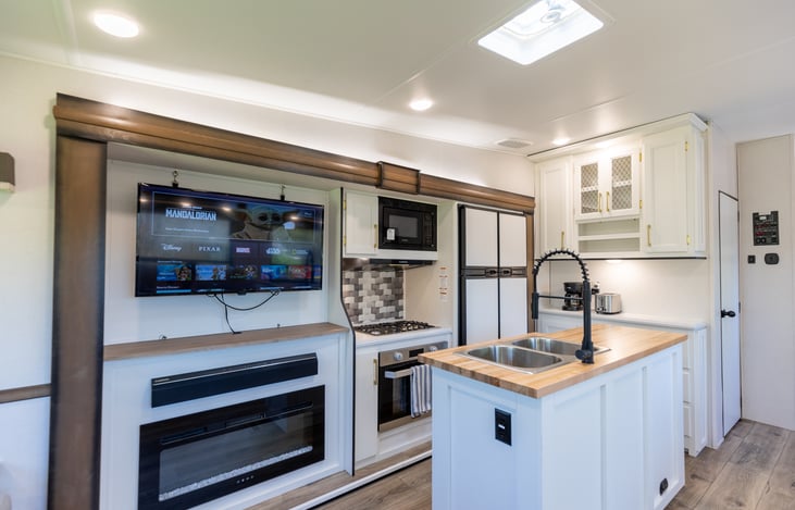 43" HD Insignia Fire TV with fireplace and Bluetooth capable sound bar that can play music through outdoor speakers.