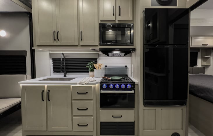 Kitchen area with all the amenities: Farmers sink, Stove, Oven, Microwave and RV Fridge,