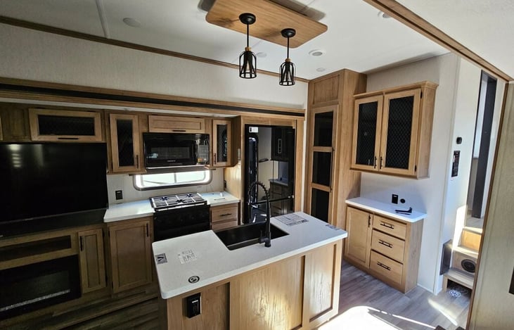 Kitchen, dining and living room. Includes smart tv, sofa/recliner, island sink, gas cooktop and oven, microwave, full-size refrigerator/freezer, pantry storage, dining table/chairs for 4 person