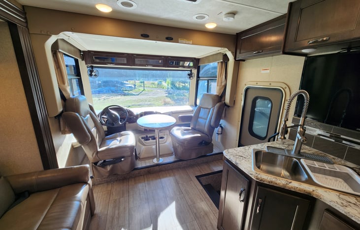 Amazing views with large windows and card table between the captain chairs. See full size bed box above captain chairs that drops down.