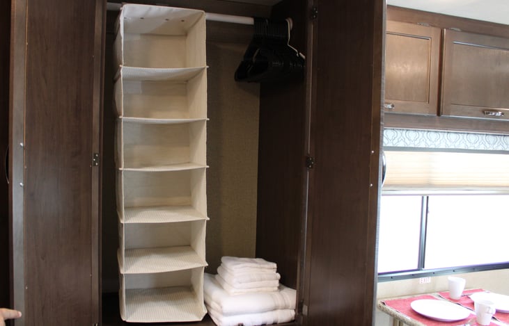 Closet with an added hanging organizer, set of towels included.