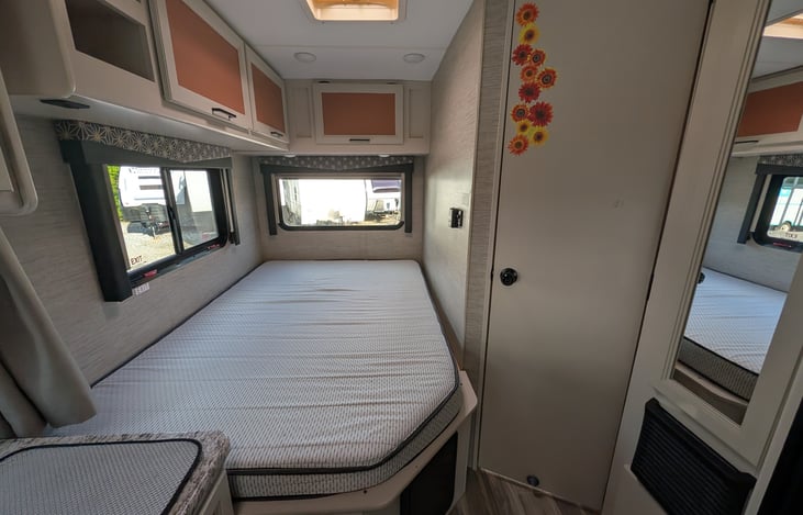 Bright, modern interior with a cute pop of color! Features a cozy rear queen bed, fully equipped kitchen, converting dinette, over-cab bunk, and an accent armchair. Clean, open, and ready for adventur