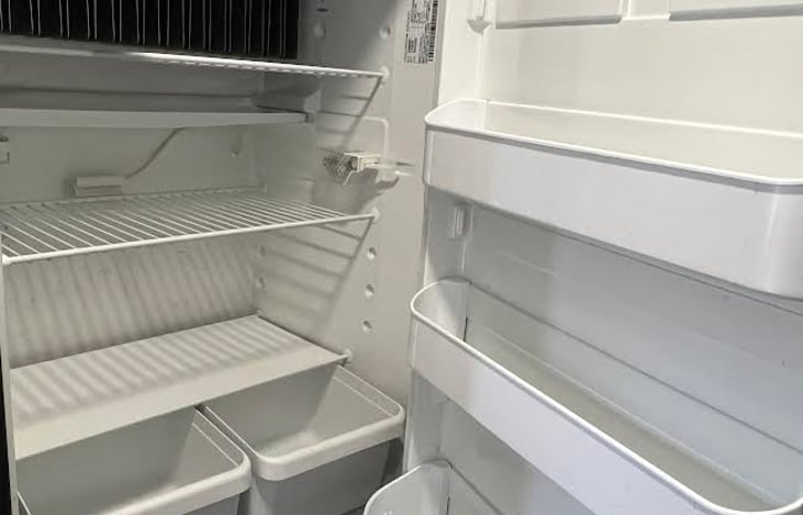 The clean refrigerator/freezer has plenty of room for your favorite foods and beverages.