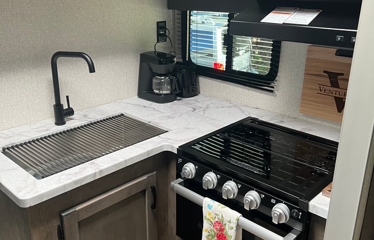 Kitchen includes oven, 4-burner stove, microwave, coffee pot & toaster.