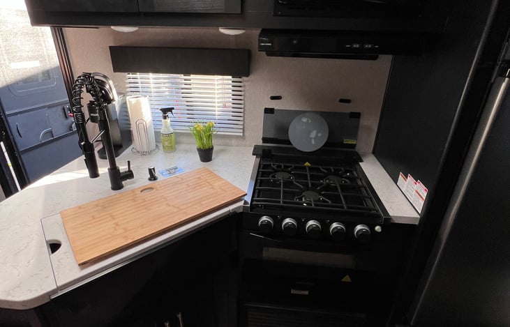 Kitchen with glass cover up on stove and cutting board