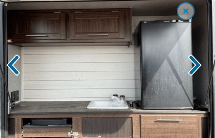 Great exterior kitchen. Sink, fridge, stove and storage.