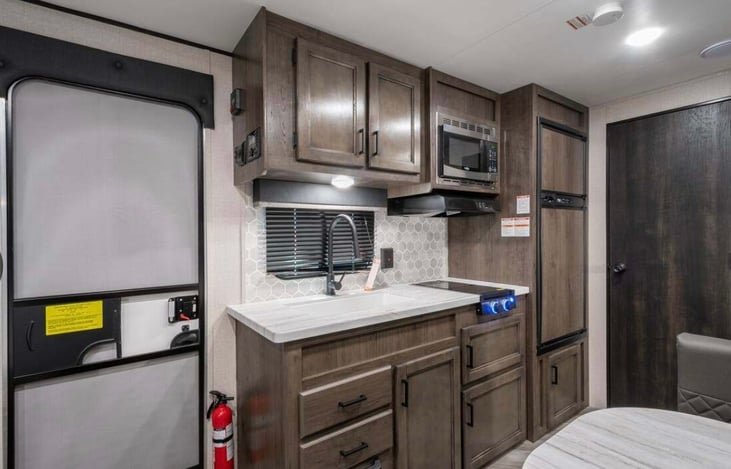 Lots of room for pots and pans and food in the refrigerator . Big sink and 2 fire burners with microwave .