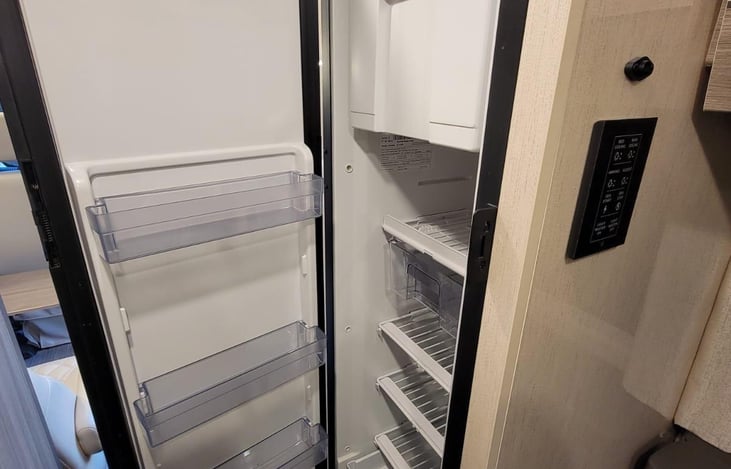 The RV contains a 5.3 cubic foot refrigerator.  Its door clicks securely shut when closed, preventing it from opening while driving.