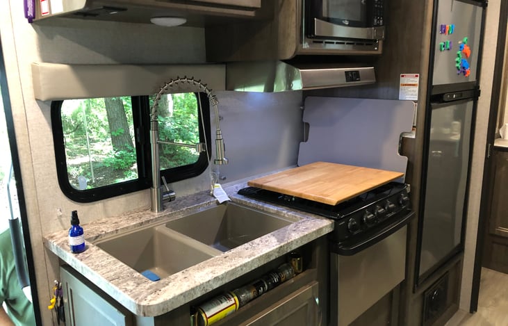 Propane stove, microwave and large refrigerator.