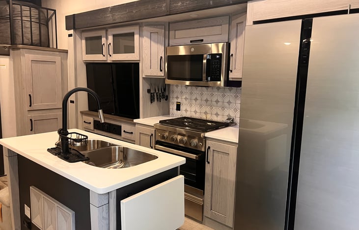 Kitchen. Dual sink has removable cutting boards and the shelf at the end of the island locks up and folds down when not in use.