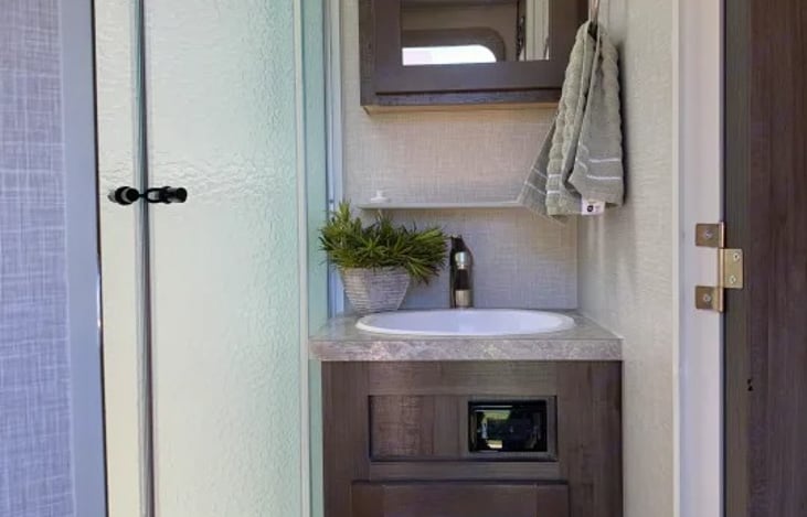 More great features are a porcelain foot-flush bowl toilet, a medicine cabinet vanity, and a high-velocity Maxxair ventilation fan with an integrated rain cover.