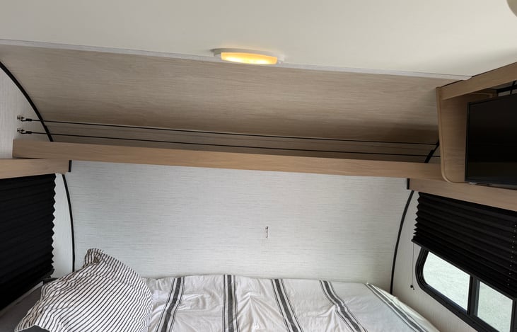 A plush, dedicated queen bed up front ensures a restful night’s sleep after a long day of exploring. Complete with overhead storage and cozy ambient lighting!