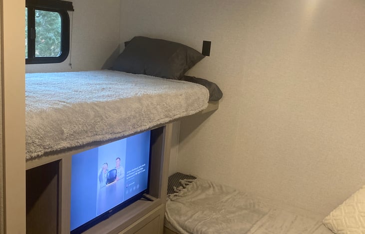 Bunkhouse includes Smart TV, games, cards, and XBox360 gaming system. Two single bunks pictured.