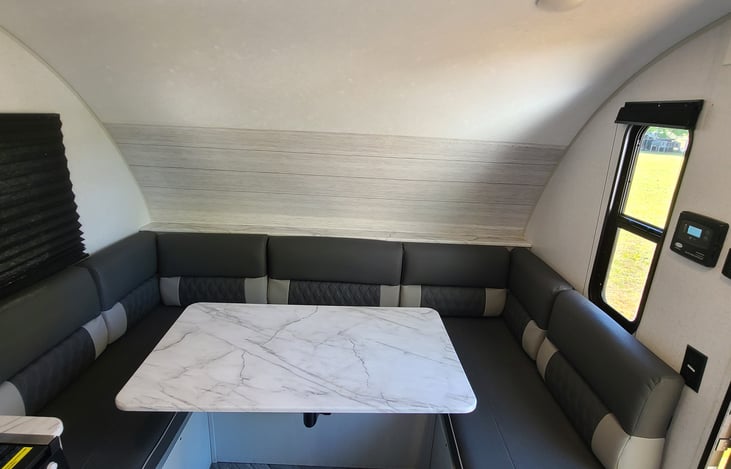 The dining table area converts into a bed. The table must be removed during transport.