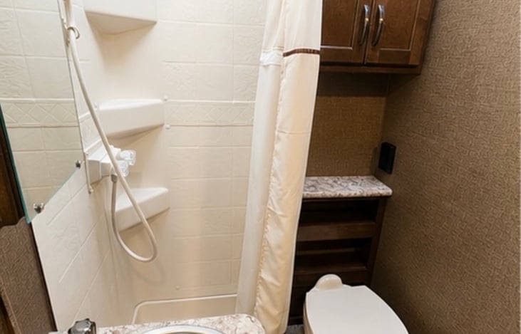 Roomy bathroom with shower, sink and toilet.