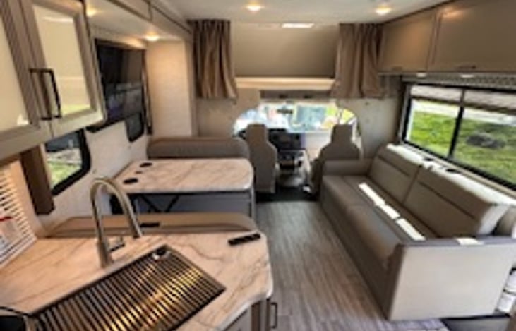 View from the kitchen looking towards the front of the RV with the bed over the cab.