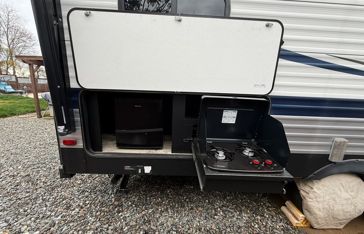 Outdoor kitchen with small fridge & 2 burner propane stove.